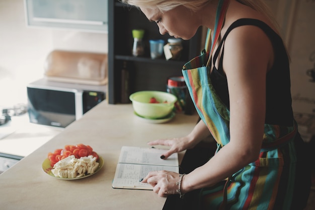 Persona cocinando y apuntando receta